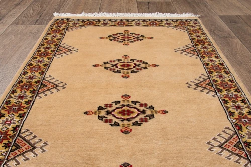 Na podłodze dywan orientalny pakistański Bukhara 70x121 cm
