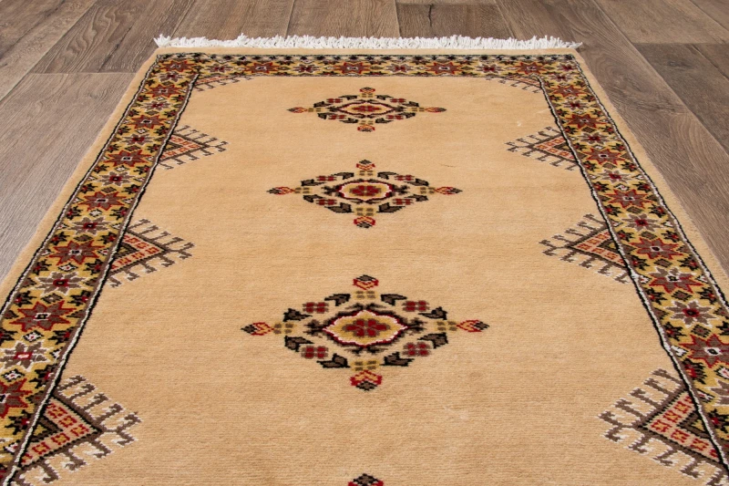 Na podłodze dywan orientalny pakistański Bukhara 70x121 cm