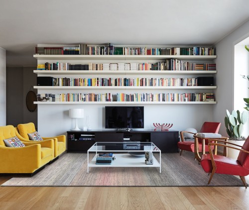 Dywan wełniany Agnella Calisia Aiko wrzosowy w pokoju dziennym na tle regału z książkami