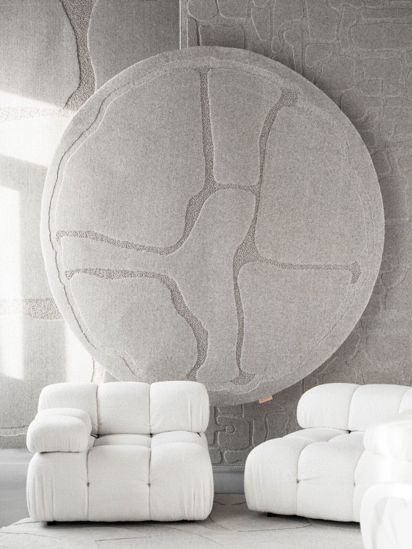 Okrągły dywan wełniany jasnoszary Agnella Ladnini Morphic Organica na ścianie
