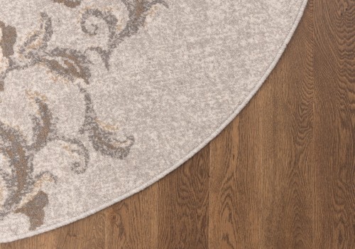 Dywan okrągły wełniany Agnella Ballata Jira szary na podłodze.jpg