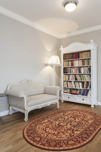 Dywan owalny wełniany Agnella Agnus Stolnik rubin w bibliotece w stylu klasycznym