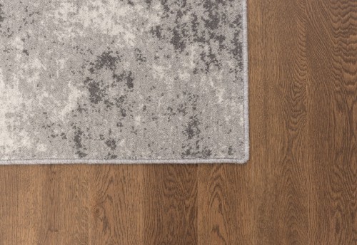 Róg dywanu wełnianego Agnella Ballata Zilka szary na podłodze