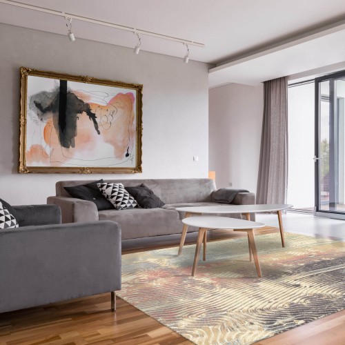 Dywan wełniany nowoczesny Agnella Isfahan Ornan kolor morski w nowoczesnym salonie z szarą kanapą i fotelem i abstrakcyjnym obrazem na ścianie