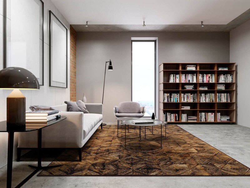 Dywan wełniany geometryczny Agnella Isfahan Estera w kolorze sahara w nowoczesnym salonie z jasnoszarą kanapą i regałem z książkami