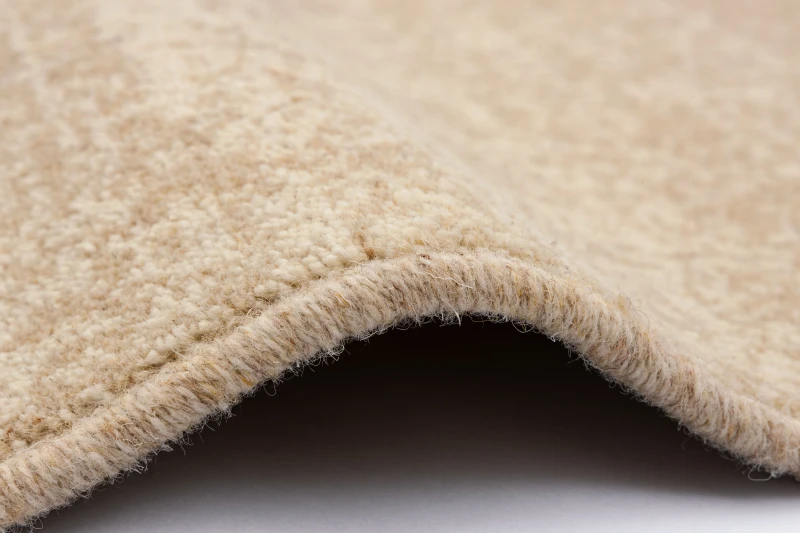Dywan wełniany Agnella Ballata Alova w kolorze beżowym - obszycie wełniane dywanu