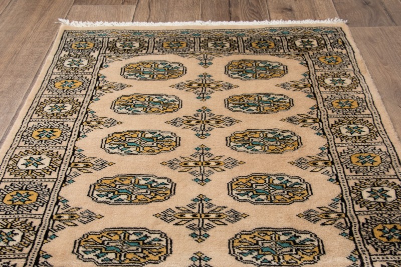 Na podłodze dywan orientalny pakistański Bukhara 79x125 cm
