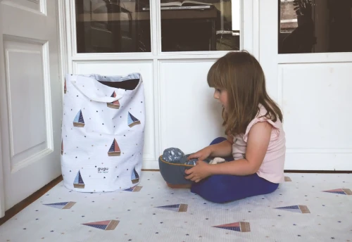 Kosz na zabawki Little Sailor i bawiąca się dziewczynka