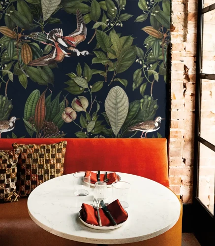 Pomarańczowa sofa w jadalni z tapetą Orange Bird.webp