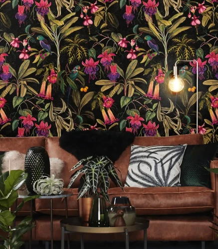 Sofa i ogrągłe stoliki z dekoracjami przy ścianie z tapetą Frida.webp