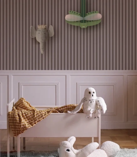 Pokój dziecięcy z tapetą w pionowe pasy Stripe Whisper Blush z białym łóżeczkiem i zabawkami.webp