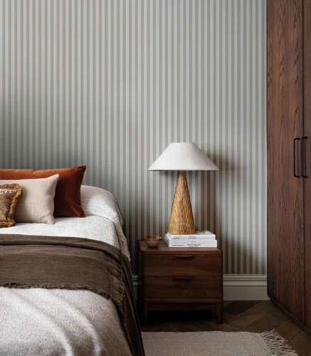 Łóżko i ciemne drewniane meble w sypialni z tapetą Stripe Tranquil Blue.webp