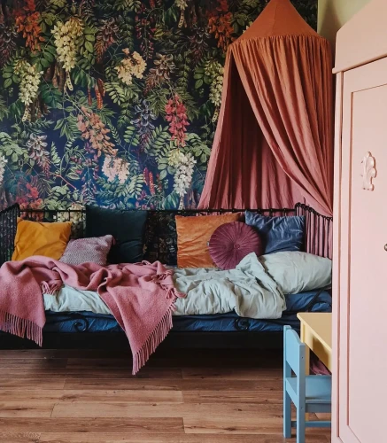 Tapeta w kwiaty na ciemnym tle Acacia Dark Blue za łóżkiem z baldachimem.webp