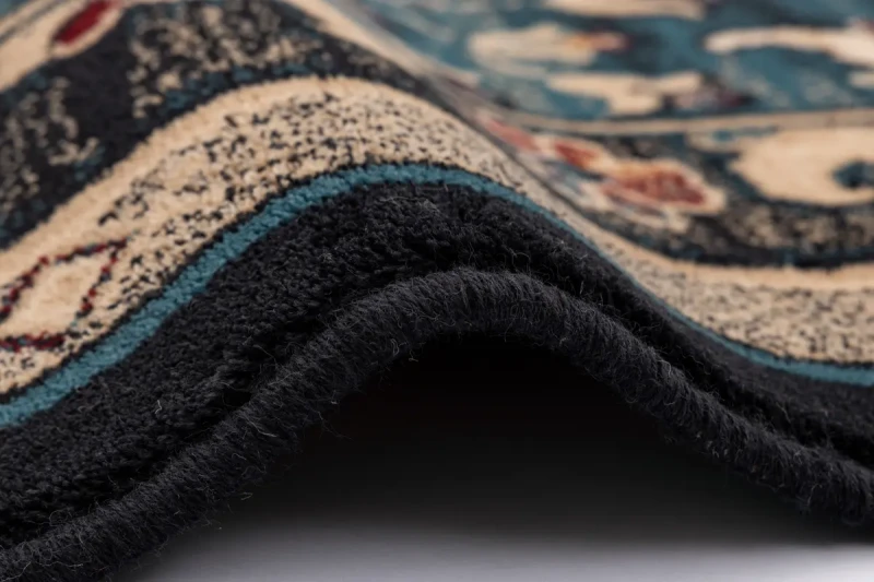 Zbliżenie runa i obszycia dywanu Agnella Isfahan Amara szmaragd