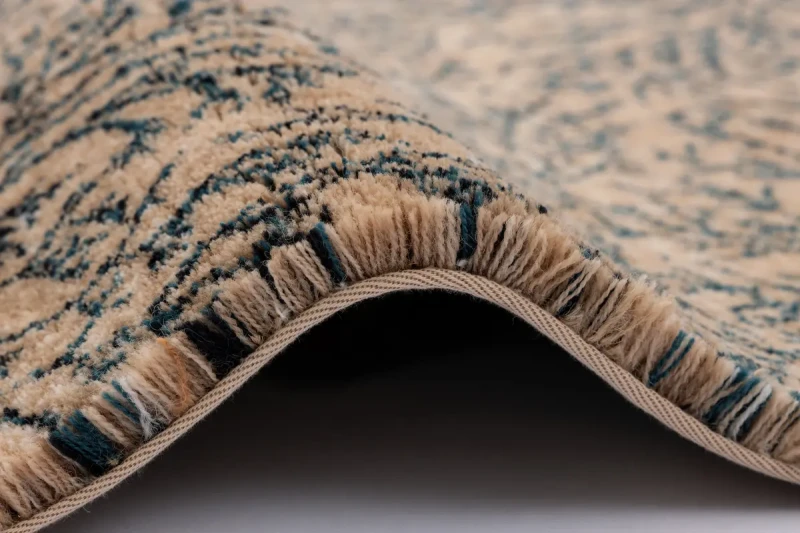 Dywan wełniany Calisia Corail jasny beż wysokość runa i wykończenie taśmą.webp