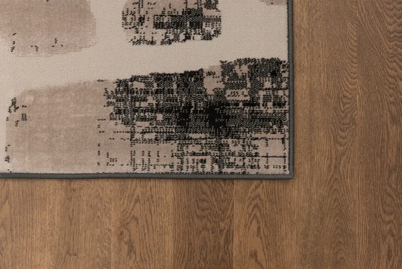 Brzeg dywanu nowoczesnego na ciemnej podłodze FD Lida Nicco beż