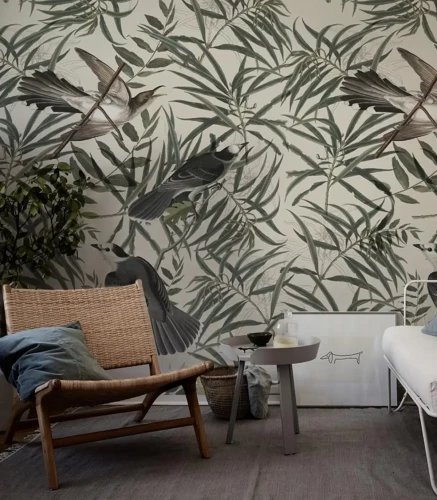 Tapeta w liście z pliszkami Wegtail w aranżacji z wiklinowym fotelem i stolikiem.webp