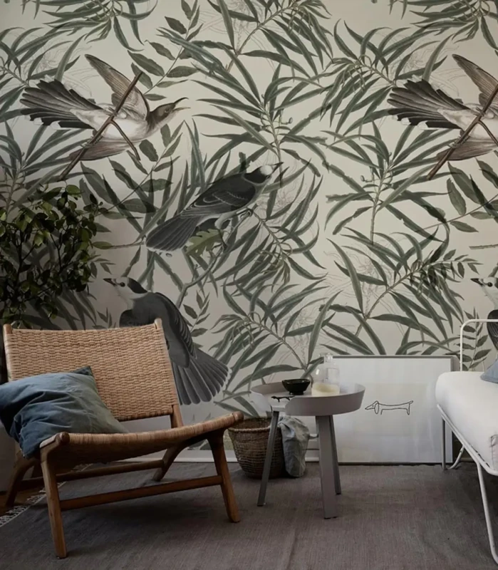 Tapeta w liście z pliszkami Wegtail w aranżacji z wiklinowym fotelem i stolikiem.webp