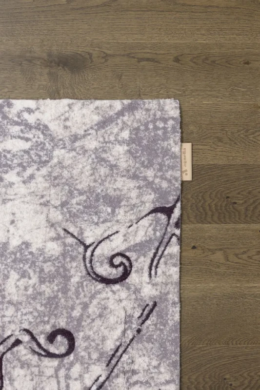 Na ciemnej podłodze róg dywanu wełnianego Agnella Opal Tomas beżowy (binding)