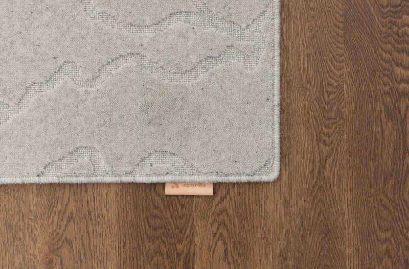 Dywan wełniany Agnella Noble Tarion jasny szary na ciemnej podłodze