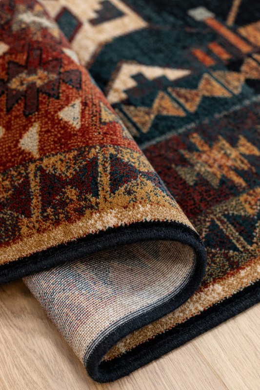 Zwinięty dywan wełniany Dywilan Omega Rohan kolor jasny rubin z widocznym spodem